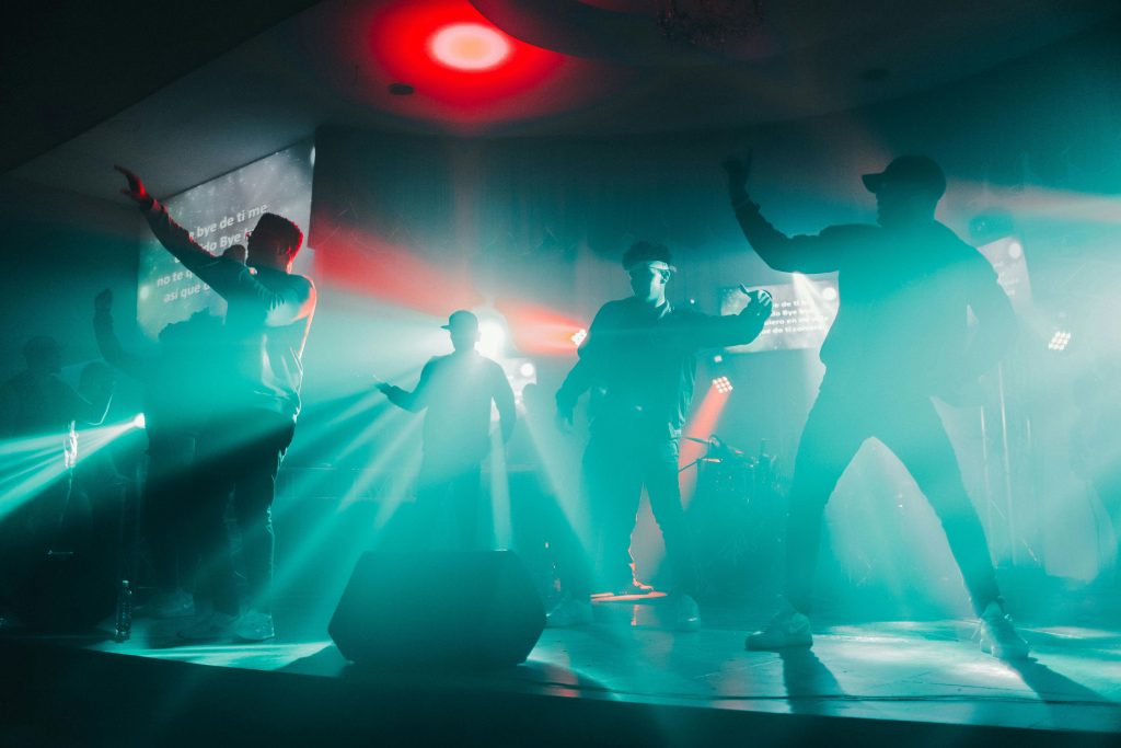 Dynamic concert scene with performers under vivid spotlights, creating an energetic atmosphere.