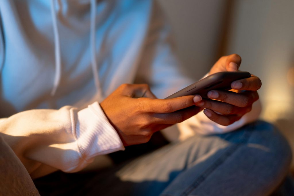 Close-up of a person holding a smartphone indoors, emphasizing digital interaction.